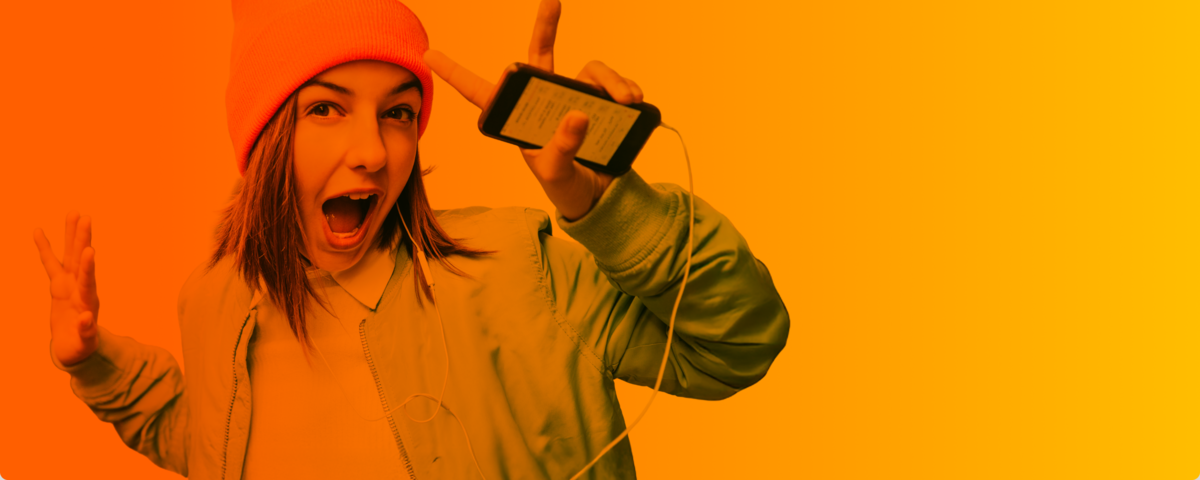 Lächelnde Frau im Auto mit lockigen Haaren hält ihr Handy und freut sich über ihren neuen Handyvertrag.