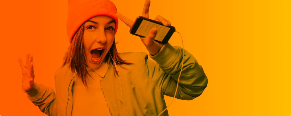 Lächelnde Frau im Auto mit lockigen Haaren hält ihr Handy und freut sich über ihren neuen Handyvertrag.