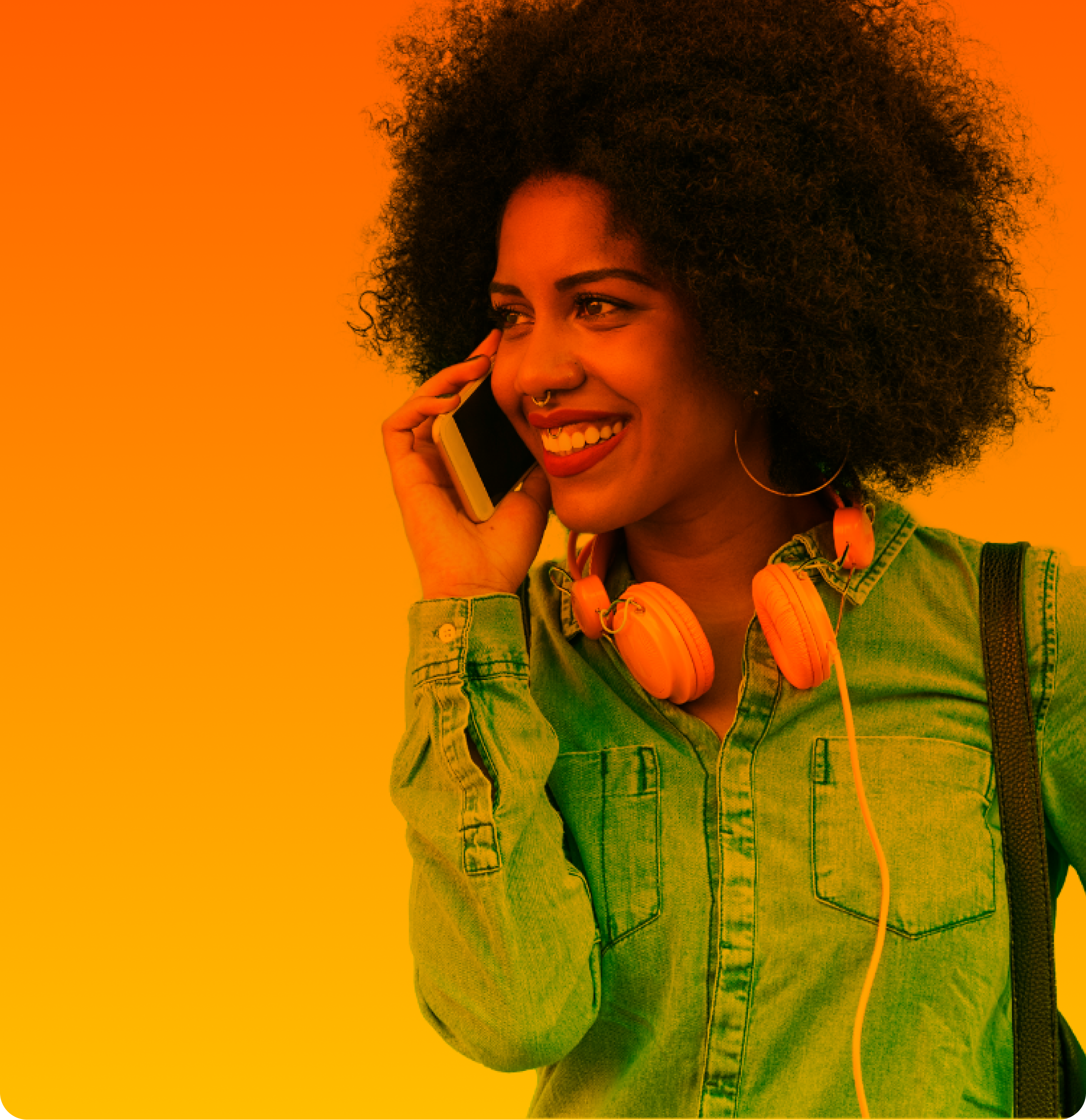 Die junge Frau mit Afrobob und Piercings telefoniert lächelnd mit ihrem Smartphone und Handyvertrag ohne Handy.