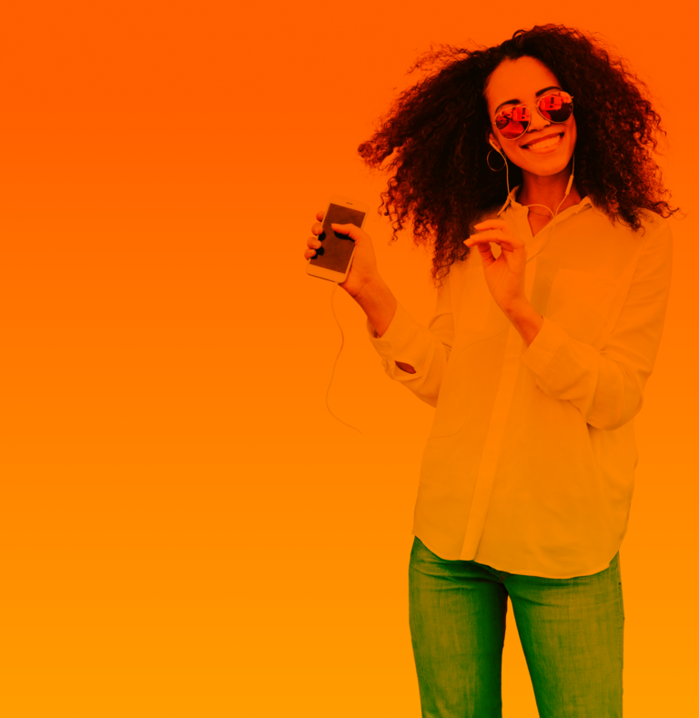 Nach einem erfolgreichem Handytarife Vergleich hört eine junge Frau Musik auf ihrem Smartphone.